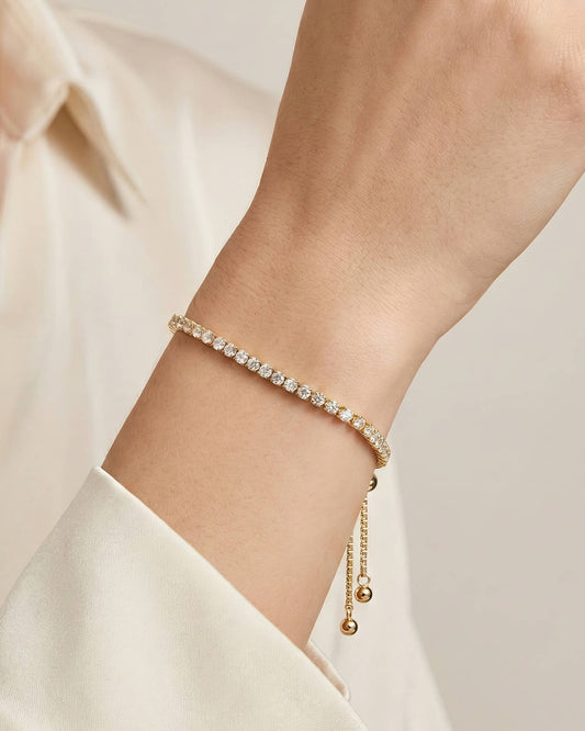 18K gold plated tennis armband met zirkonia gedragen om de pols van een model. Hyperrealistische huidstructuur met natuurlijke details en luxe uitstraling. Perfecte pasvorm voor een elegante, stijlvolle look.