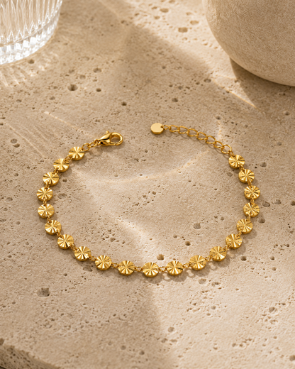 18K gold plated disc armband met ronde gouden schijfjes op een witte achtergrond met subtiele schaduw. Minimalistische luxe productfoto van een verstelbare damesarmband
