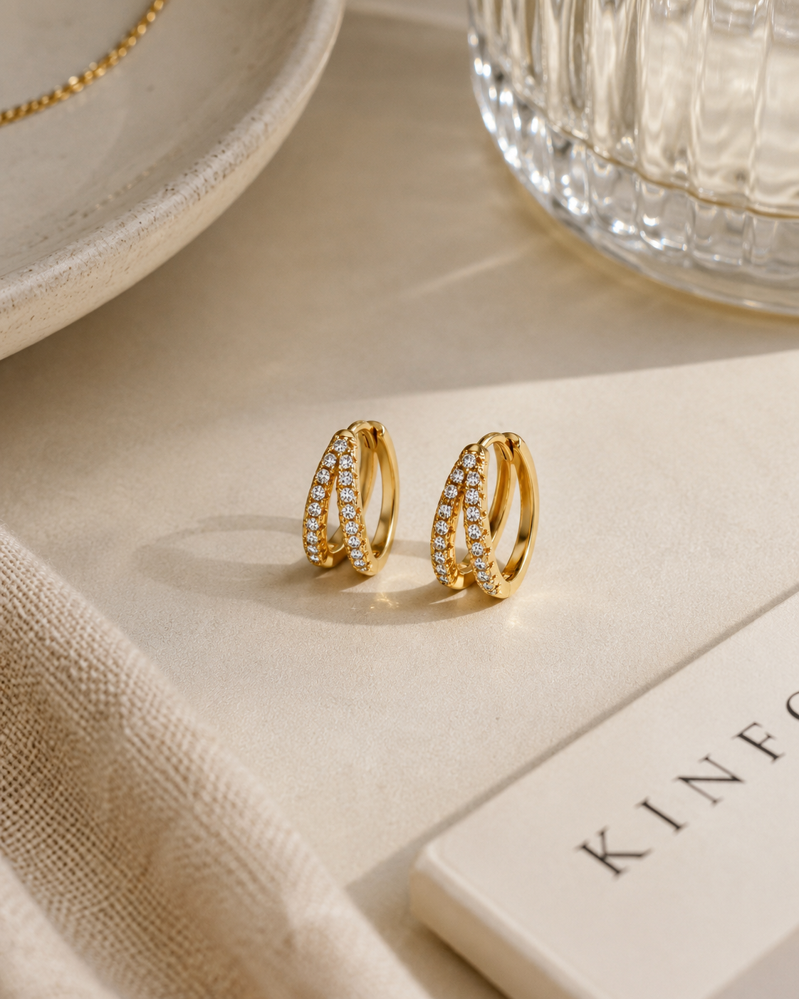 Gouden 18K gold plated pavé zirkonia oorbellen op een stijlvolle beige tafelsetting