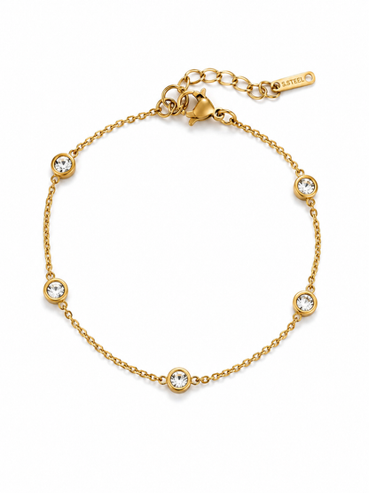 Gouden armband met ronde zirkonia steentjes op witte achtergrond