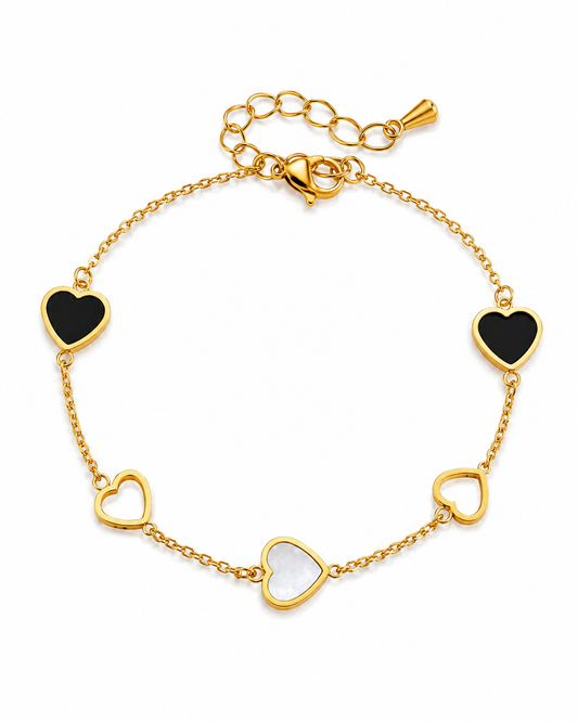 Gouden armband met zwarte en witte hartjes op witte achtergrond