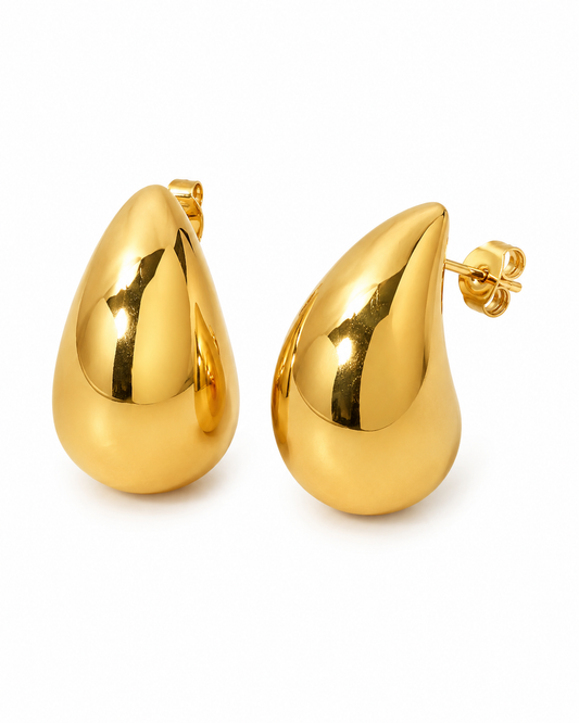 18K gold plated druppel oorbellen met hoogglans afwerking op een witte achtergrond met subtiele schaduw. Minimalistische luxe productfoto van elegante gouden damesoorbellen.