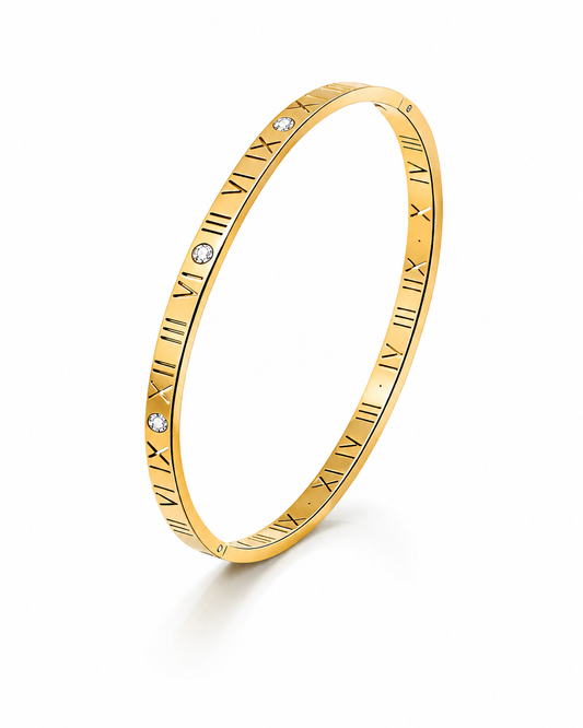Goudkleurige armband met Romeinse cijfers en vier zirkonia stenen.