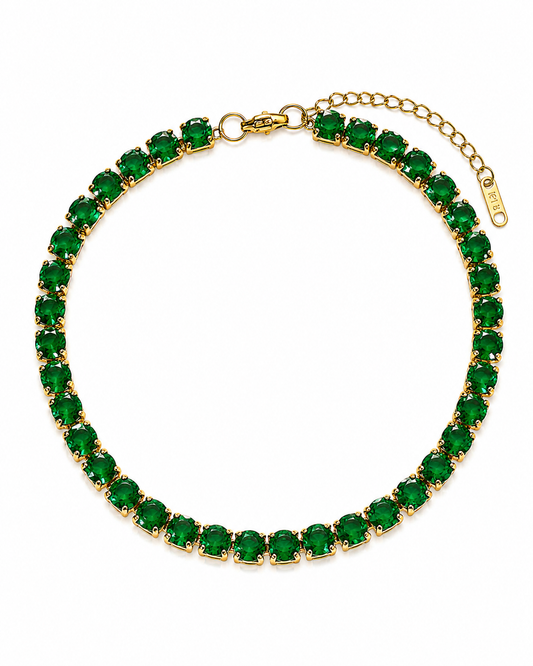 Groene tennis armband met goudkleurige zetting op witte achtergrond