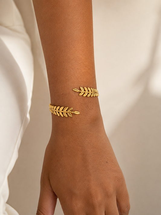 Model draagt 18K goudkleurige bladeren armband om de pols