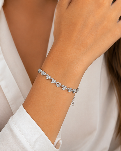 Zilveren hartjes armband stijlvol gepresenteerd op een natuurstenen tafel